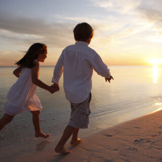 Boy and girl running down beach | Hilton Sandestin Beach