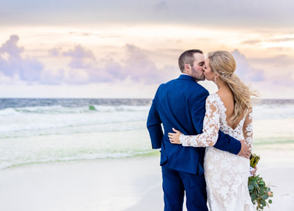 Newlyweds kiss on the beach at Hilton Sandestin