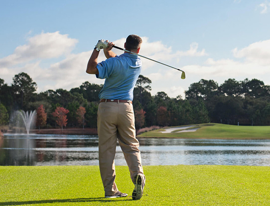 Man Golfing on an golf course with a lake