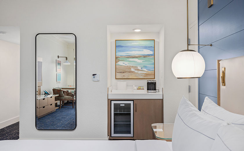 A wetbar with a photo of the ocean framed above it