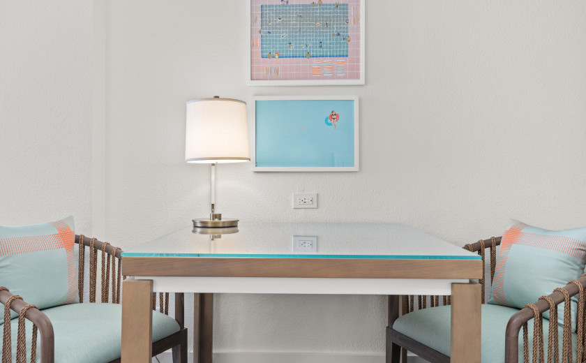 table with two chairs and pool-themed art