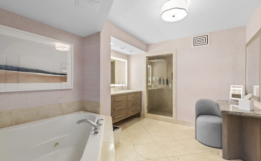 bathroom with pink wallpaper and a jacuzzi tub